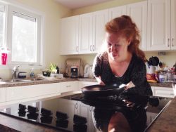 Woman with short arms cooking in her kitchen.